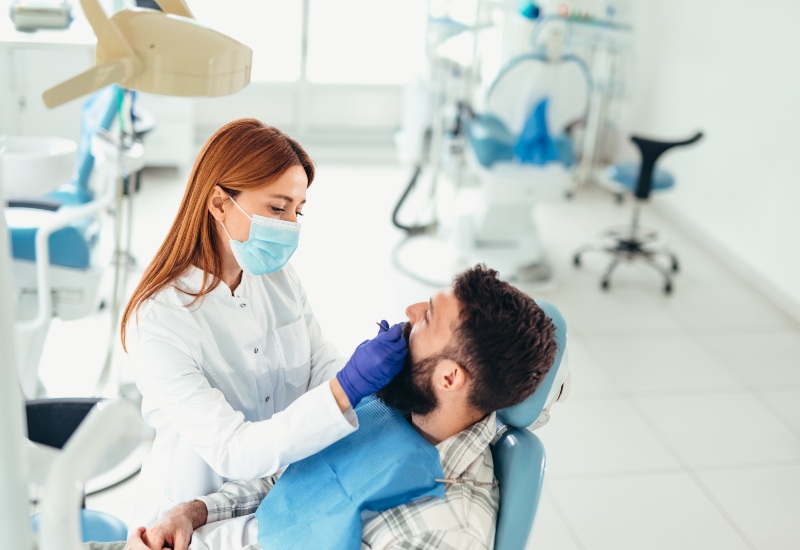 Dentist checking patient’s teeth at modern dental clinic in Antioch, IL