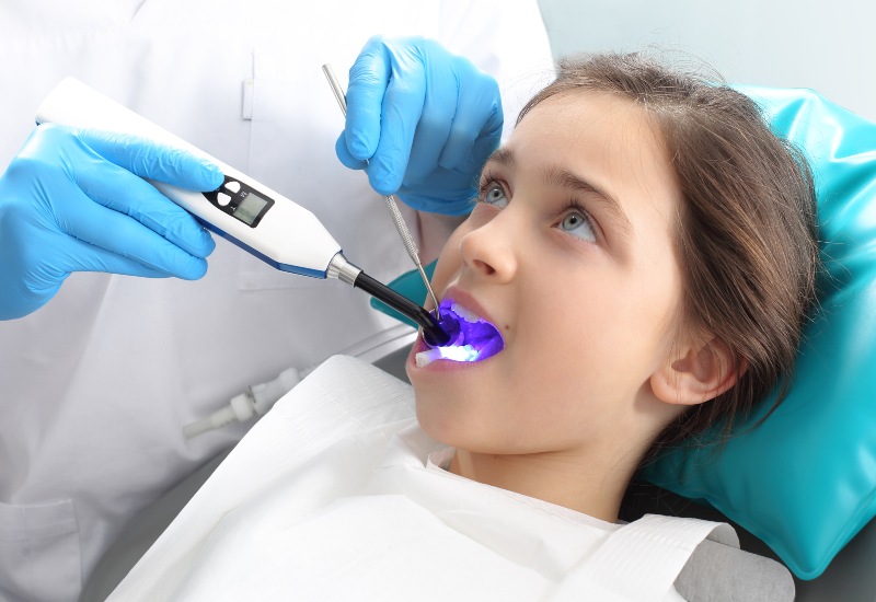 Dentist applying fluoride treatment with dental tools during a checkup in Antioch, IL