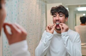 Person fitting dental night guard at mirror in bathroom, Antioch, IL